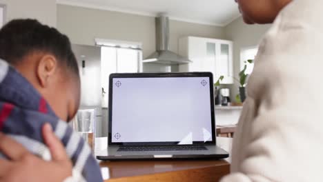 Unaltered-african-american-mother-and-sick-daughter-using-laptop-with-copy-space,-in-slow-motion
