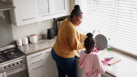 Glückliche-Afroamerikanische-Mutter-Und-Tochter,-Die-In-Der-Küche-Geschirr-Spülen,-Zeitlupe