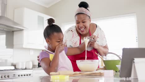 Glückliche,-Unveränderte-Afroamerikanische-Mutter-Und-Tochter-Backen-In-Der-Küche-Mit-Einem-Tablet,-In-Zeitlupe