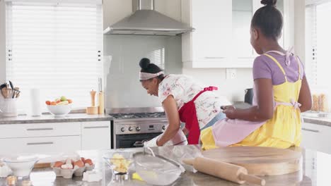 Glückliche,-Unveränderte-Afroamerikanische-Mutter-Und-Tochter-Backen,-Kuchen-Aus-Dem-Ofen-Nehmen,-Zeitlupe
