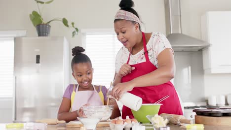 Feliz-Madre-E-Hija-Afroamericanas-Inalteradas-Horneando-En-La-Cocina,-En-Cámara-Lenta