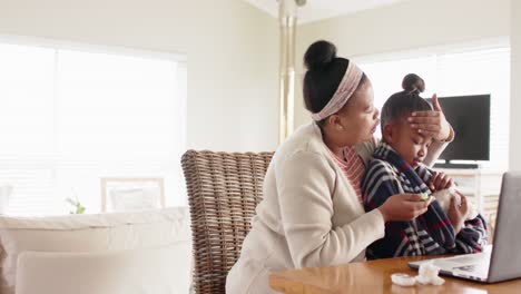 Unveränderte-Afroamerikanische-Mutter-Und-Kranke-Tochter,-Die-Laptop-Für-Videoanrufe-Beim-Arzt-Benutzen,-Zeitlupe
