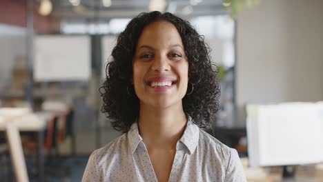 Portrait-of-happy-biracial-casual-businesswoman-smiling-at-office,-slow-motion