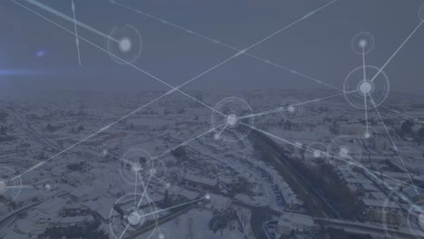 Animation-of-network-of-connections-against-aerial-view-of-winter-landscape