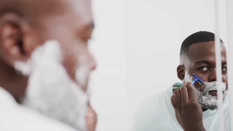 Afroamerikanischer-Mann-Rasiert-Bart-Mit-Rasiermesser-Im-Badezimmer,-In-Zeitlupe