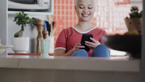 Happy-biracial-woman-using-smartphone-at-home-in-slow-motion