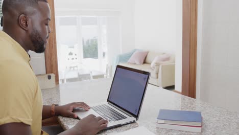 Afroamerikanischer-Mann-Benutzt-Laptop-Mit-Kopierplatz-Auf-Dem-Bildschirm,-In-Zeitlupe