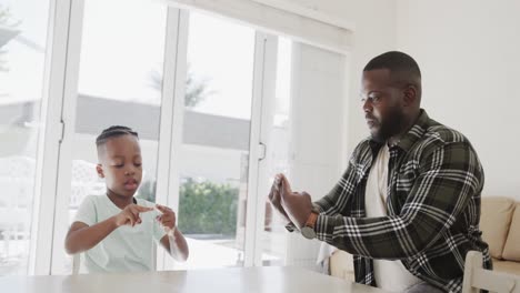 Happy-african-american-father-and-son-using-sign-language,-in-slow-motion