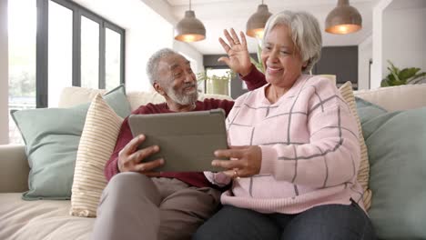 Glückliches-älteres-Gemischtrassiges-Paar,-Das-Ein-Tablet-Für-Videoanrufe-Nutzt,-Unverändert,-In-Zeitlupe