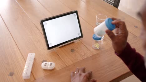 Close-up-of-senior-biracial-man-using-tablet-with-copy-space-on-screen,-slow-motion
