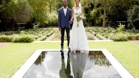Portrait-of-happy-african-american-bride-and-groom-at-their-wedding-in-sunny-garden,-slow-motion