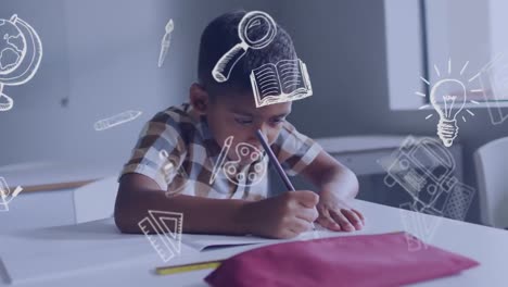 Animation-of-school-icons-over-biracial-schoolboy-concentrating-writing-at-desk-in-class