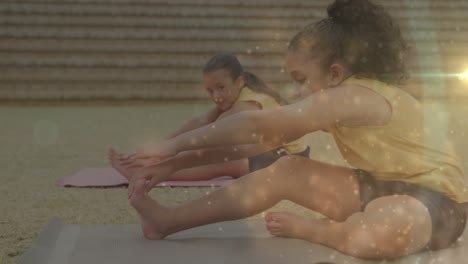 Animation-Von-Bokeh-Lichtern-über-Verschiedenen-Schulmädchen,-Die-Im-Yoga-Kurs-Im-Freien-Trainieren