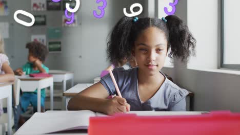 Animation-of-numbers-over-happy-biracial-schoolgirl-writing-at-desk-in-class