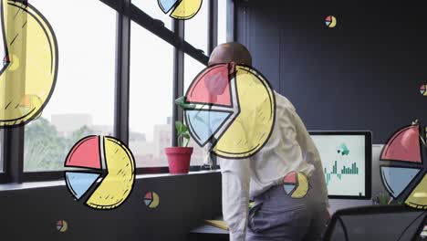 Animation-of-multiple-pie-graph-icons-over-biracial-man-in-face-mask-looking-out-of-window-at-office