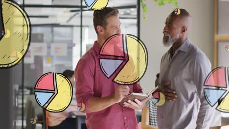 Animation-of-multiple-pie-graph-icons-over-two-diverse-men-smiing-while-discussing-at-office