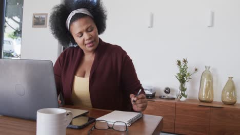 Afroamerikanische-Frau-In-Übergröße-Benutzt-Laptop-Und-Macht-Sich-Notizen,-Unverändert,-Kopierraum,-Zeitlupe