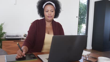 Mujer-Afroamericana-De-Talla-Grande-Usando-Laptop-Y-Tableta-Gráfica,-Inalterada,-Cámara-Lenta