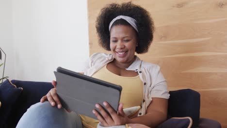 Portrait-of-happy-african-american-plus-size-woman-using-tablet-and-smiling,-unaltered,-slow-motion