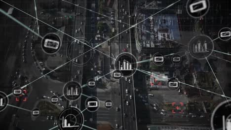 Animation-of-network-of-digital-icons-over-spinning-globe-against-aerial-view-of-city-traffic