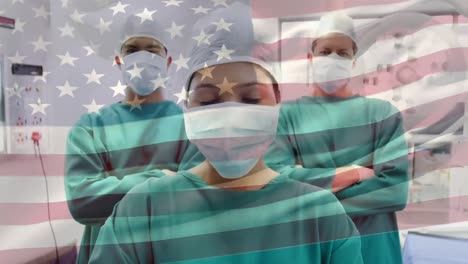 Animation-of-waving-american-flag-against-team-of-diverse-surgeons-standing-together-at-hospital