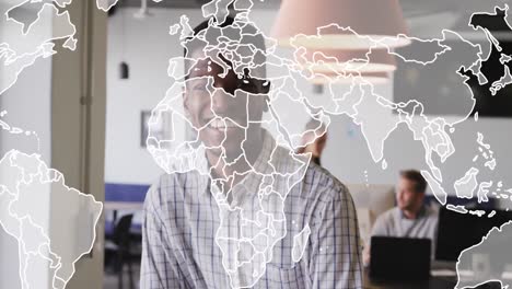 Animation-of-world-map-against-african-american-man-smiling-at-office