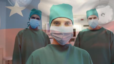 Animation-of-waving-texas-flag-against-team-of-diverse-surgeons-standing-together-at-hospital