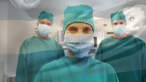 Animation-of-waving-argentina-flag-against-team-of-diverse-surgeons-standing-together-at-hospital