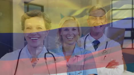 Animation-Der-Flagge-Kolumbiens-über-Einem-Team-Verschiedener-Ärzte-Und-Gesundheitspersonal,-Die-Das-Krankenhaus-Anlächeln