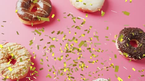 Animation-of-confetti-falling-over-donuts-on-pink-background