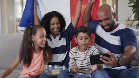 Padres-Birraciales,-Hijo-E-Hija-Tomándose-Selfie-Con-Palomitas-De-Maíz-Y-Bandera-Francesa,-Cámara-Lenta