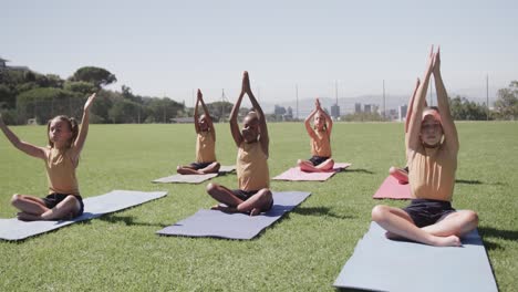 Konzentrierte-Verschiedene-Schulmädchen,-Die-In-Zeitlupe-Yoga-Praktizieren-Und-Im-Stadion-Meditieren