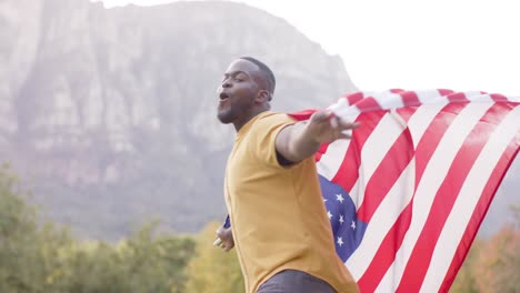 Portrait-of-african-american-man-holding-flag-of-usa-in-garden,-slow-motion