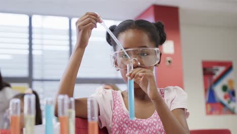 Focused-african-american-elementary-school-schoolgirl-with-goggles-in-lab-in-slow-motion