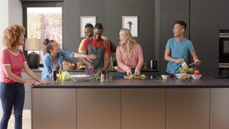 Happy-diverse-group-of-friends-preapring-meal-in-kitchen,-slow-motion