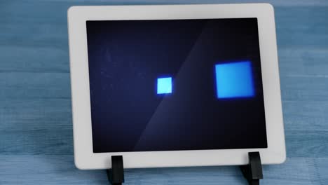 Animation-of-blue-squares-flickering-data-processing-on-tablet-screen