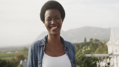 Retrato-De-Una-Feliz-Mujer-Afroamericana-Sonriendo-En-Una-Terraza-Soleada,-Cámara-Lenta