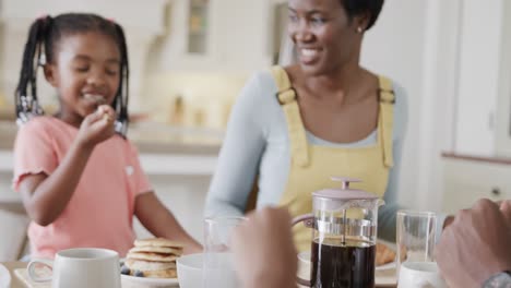Glückliche-Afroamerikanische-Mutter-Mit-Sohn-Und-Tochter-Beim-Essen-Im-Esszimmer,-Zeitlupe