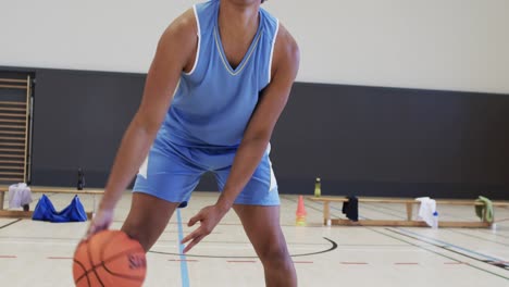 Porträt-Eines-Afroamerikanischen-Männlichen-Basketballspielers,-Der-In-Zeitlupe-Auf-Dem-Hallenplatz-Spielt