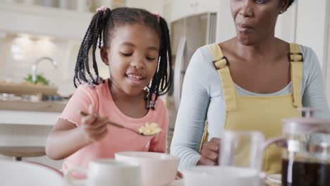 Feliz-Madre-E-Hija-Afroamericana-Disfrutando-De-La-Comida-En-El-Comedor,-Cámara-Lenta