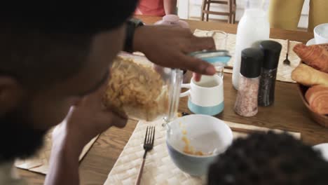 Happy-african-american-couple-with-son-and-daughter-serving-meal-in-kitchen,-slow-motion