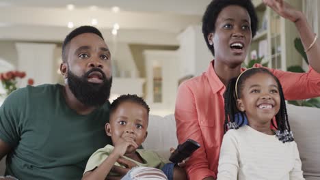 Aufgeregt-Afroamerikanische-Eltern-Mit-Sohn-Und-Tochter,-Die-Zu-Hause-Sport-Im-Fernsehen-Schauen,-Zeitlupe