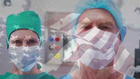 Animation-of-waving-usa-flag-over-portrait-of-caucasian-male-and-female-surgeons-at-hospital