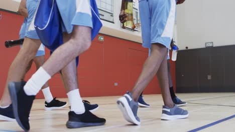 Diverse-male-basketball-team-training-in-indoor-court,-in-slow-motion