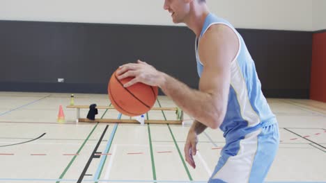 Happy-diverse-male-basketball-team-training-in-indoor-court,-in-slow-motion