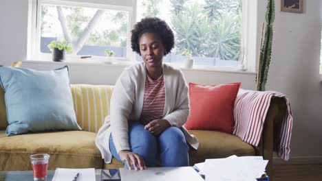 Müde-Afroamerikanische-Frau,-Die-Zu-Hause-Arbeitet,-Auf-Der-Couch-Sitzt-Und-Den-Laptop-Schließt,-Zeitlupe