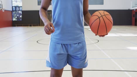 Nahaufnahme-Eines-Afroamerikanischen-Männlichen-Basketballspielers,-Der-Auf-Dem-Hallenplatz-Einen-Ball-Schießt,-Zeitlupe