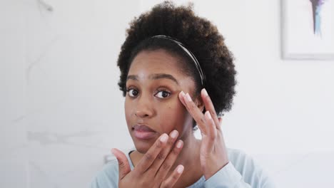 Afroamerikanische-Frau,-Die-Ihre-Haut-überprüft,-Ihr-Gesicht-Im-Badezimmerspiegel-Betrachtet,-Zeitlupe