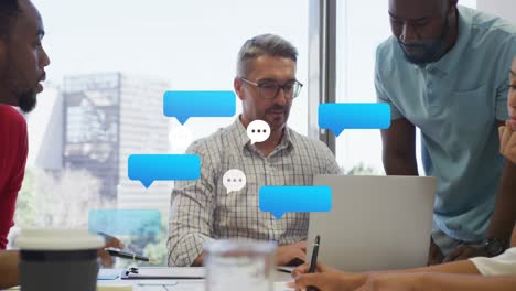 Animation-of-black-speech-bubbles-floating-against-diverse-men-discussing-together-at-office