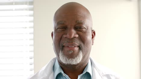 Porträt-Eines-Glücklichen-älteren-Afroamerikanischen-Arztes,-Der-In-Die-Kamera-Blickt-Und-In-Zeitlupe-Lächelt